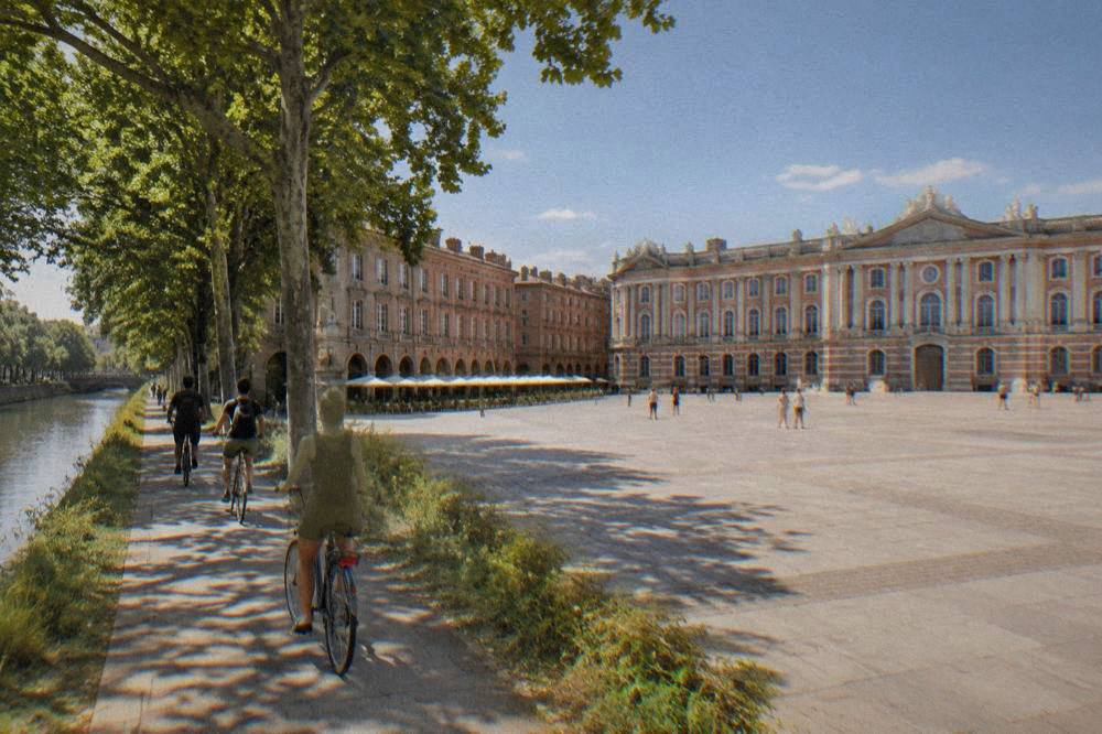 Cyclists riding along a tree lined canal path near Toulouse