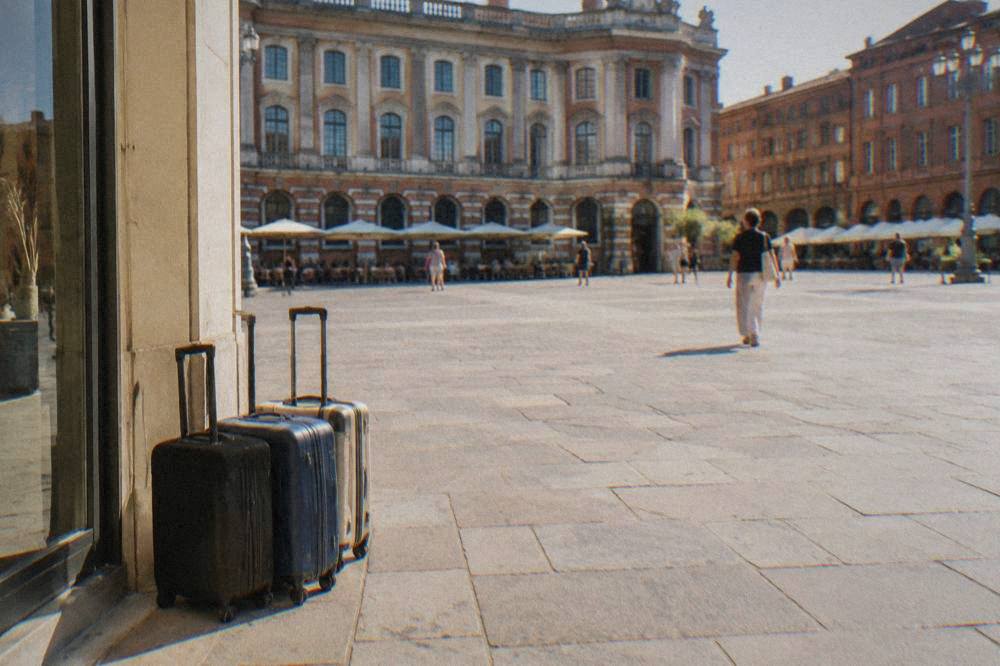Suitcases parked in the corner of a bright shop entrance in a French city