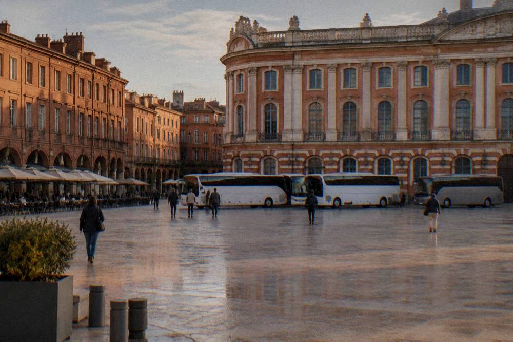Coaches parked at a departure point in a French city in the morning