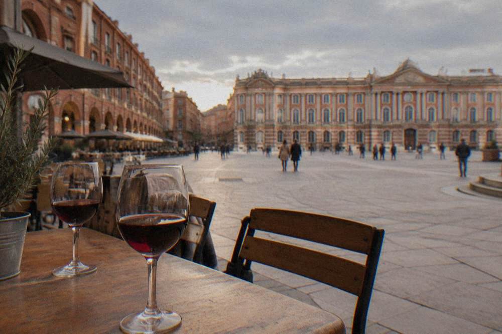 Glasses of red wine on a wooden table in a small Toulouse wine bar