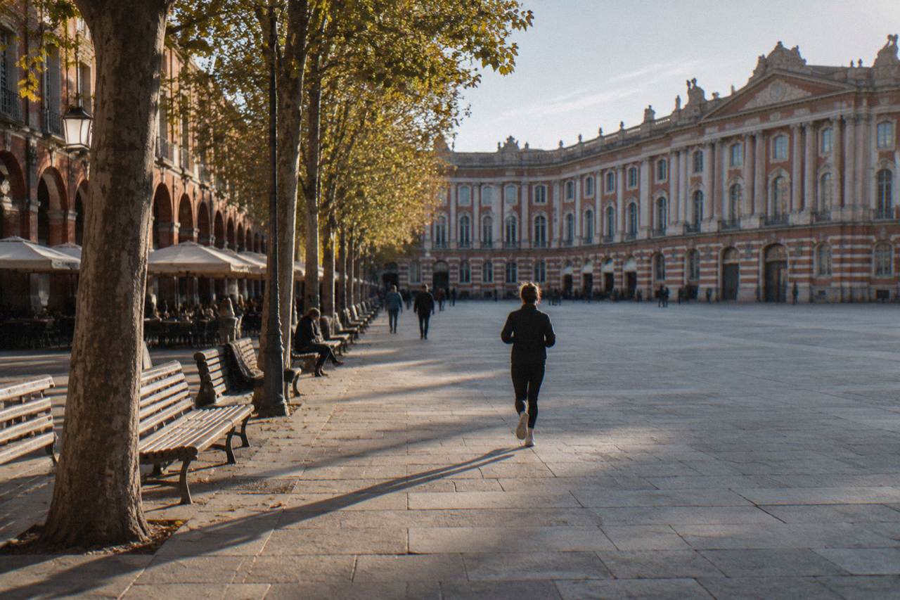 Tree-lined path with benches in a sunny public garden in Toulouse