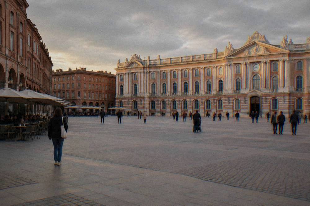 The interior courtyard of a Toulouse museum with stone arches and visitors