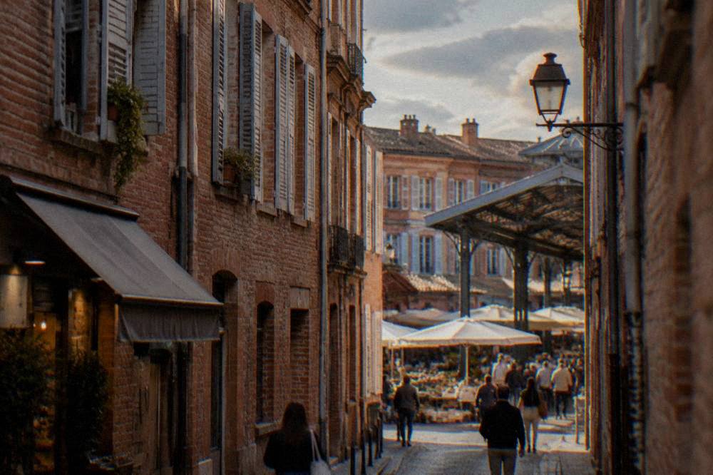 A narrow street in the Carmes quarter of Toulouse lined with pink brick walls