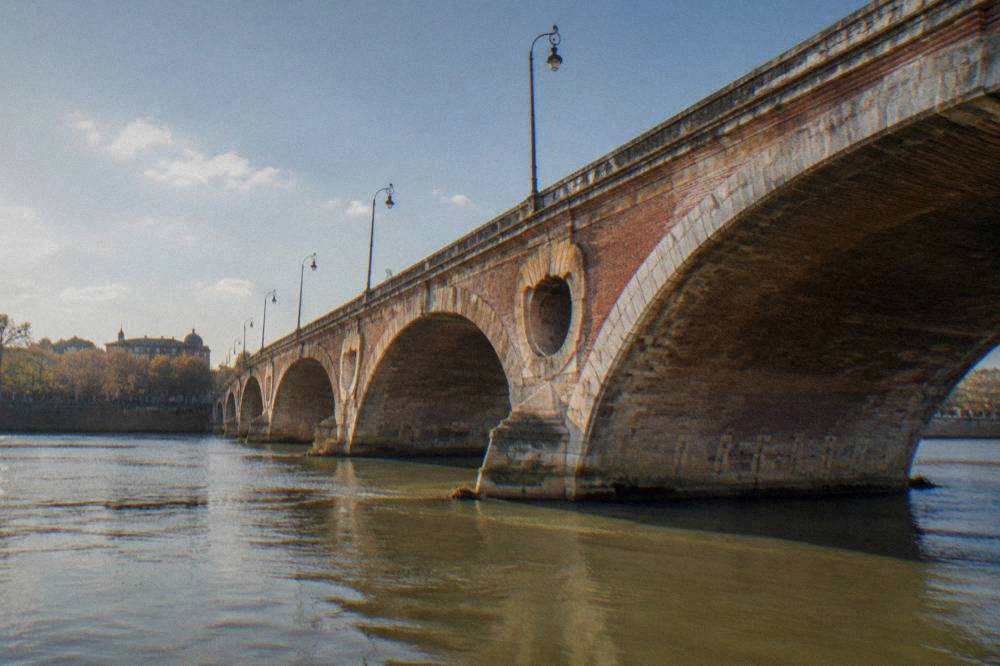 Sunlight over the Garonne river in Toulouse with the Pont Neuf in the foreground