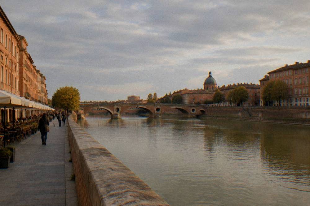 A quiet Toulouse street with cafes and pink brick apartment fronts