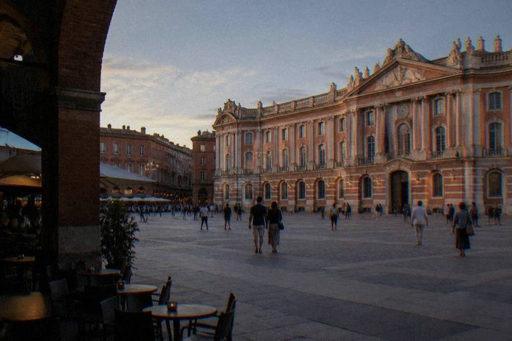 Visitors walking across the square in front of the Capitole building in Toulouse