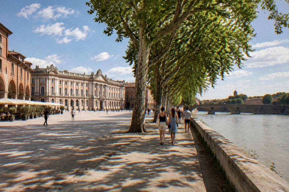 Walkers on a Toulouse riverside path under summer clouds above the Garonne