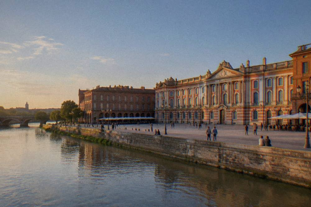 The Garonne river flowing past Toulouse on a mild sunny afternoon with people walking along the bank