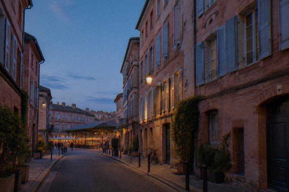 A quiet residential street in the Carmes quarter of Toulouse with pink facades
