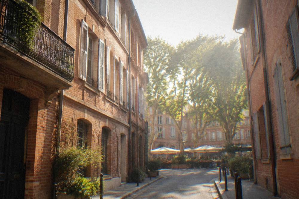 Narrow quiet street of pink townhouses in the Saint-Aubin quarter of Toulouse