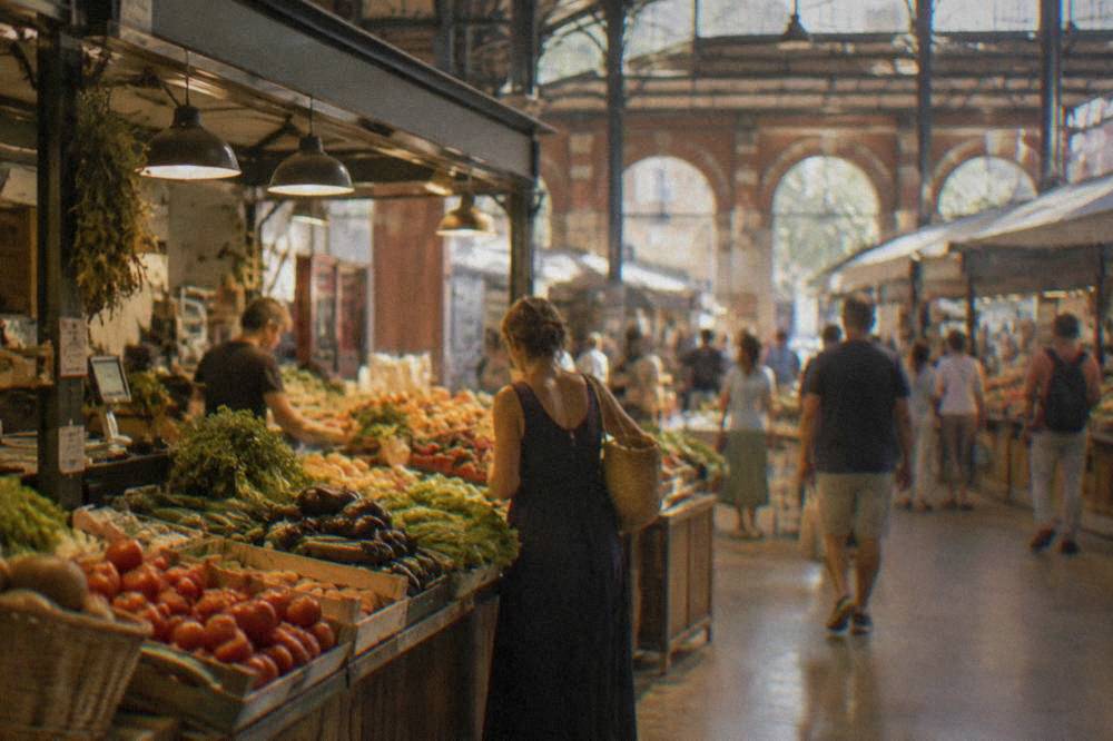A covered market hall interior with food stalls and customers in Toulouse