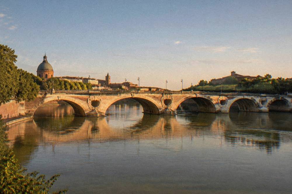 The Pont Neuf bridge in Toulouse reflected in the Garonne river at night
