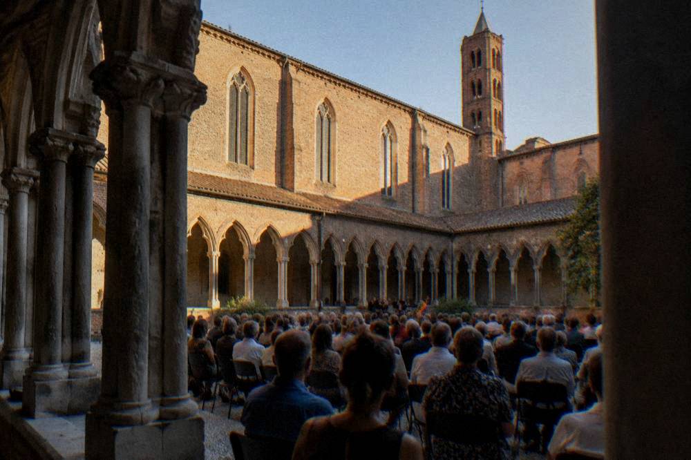 A concert audience seated inside the cloister of the Couvent des Jacobins in Toulouse