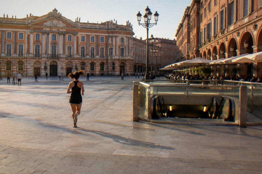 A metro station entrance in Toulouse lit up in the evening