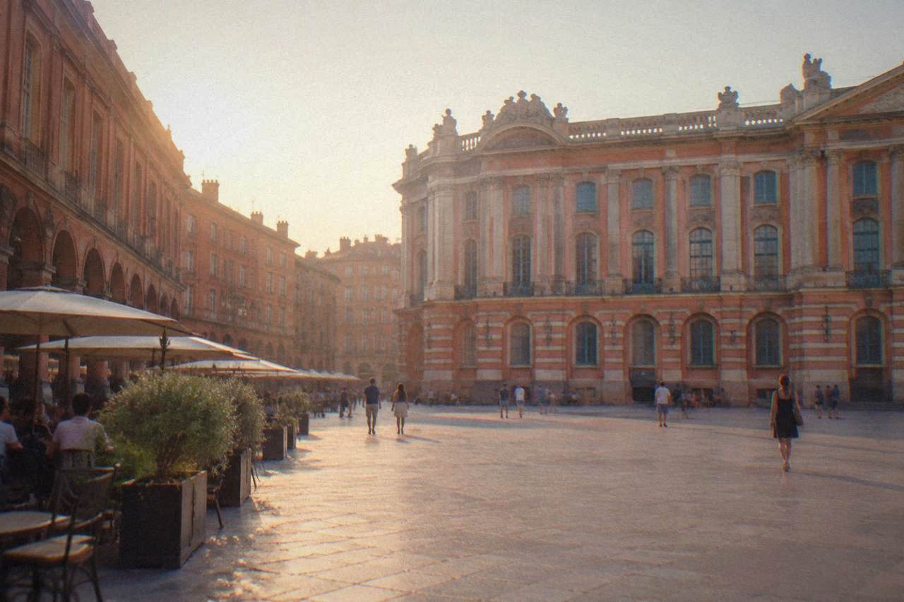 Pink brick buildings and a quiet square in Toulouse at golden hour